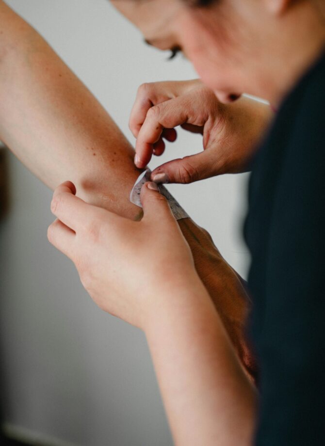 Verpleegkundige kleeft een pleister op de arm van een patiënt